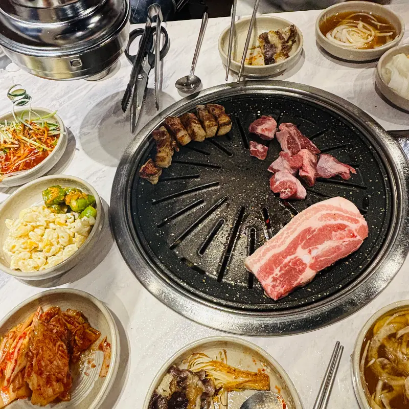 다양한 곁들임 메뉴와 구워진 고기