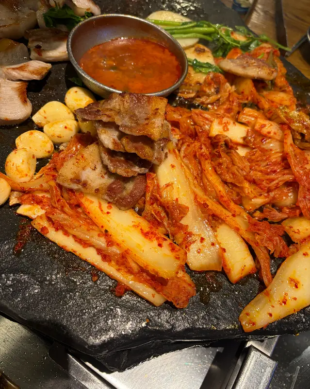 돌판 위에 김치와 함께 구워지는 삼겹살