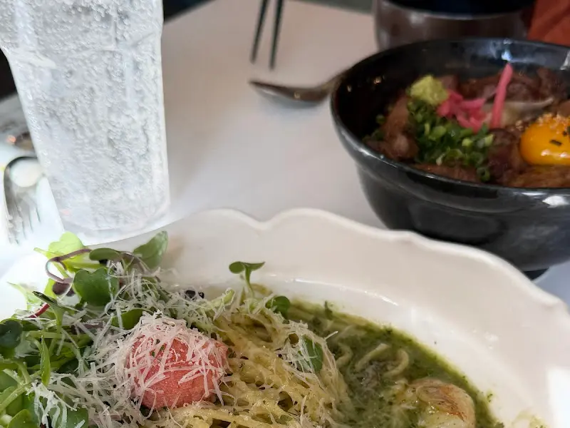 테이블 위에 놓인 명란 바질 오일 파스타와 야키니쿠동