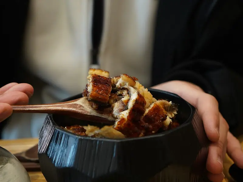 나무 주걱으로 히츠마부시를 맛보는 모습