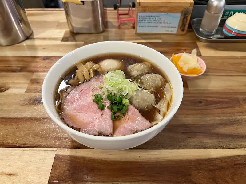 쇼유 라멘의 클로즈업 샷. 완탕, 차슈, 계란 등 다양한 토핑이 보인다.