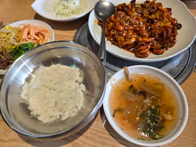 쭈꾸미 볶음과 비빔밥 재료가 함께 놓인 테이블