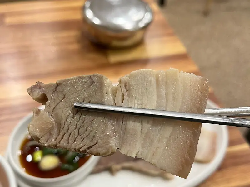 젓가락으로 집어올린 야들야들한 수육