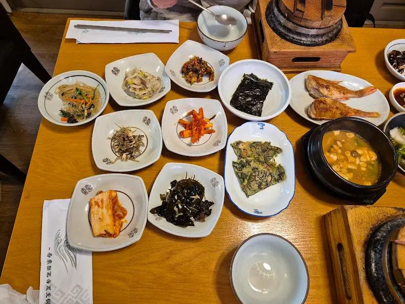 돌솥과 뚝배기, 반찬 그릇이 놓여있는 테이블 전경