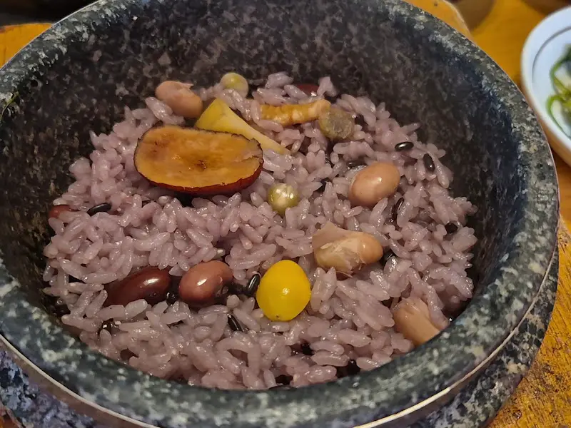 돌솥밥 안의 밥과 다양한 견과류, 고명들이 보인다.