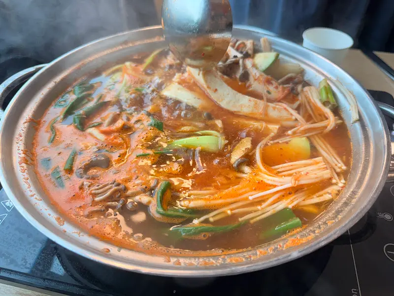 국자로 두부전골을 뜨는 모습