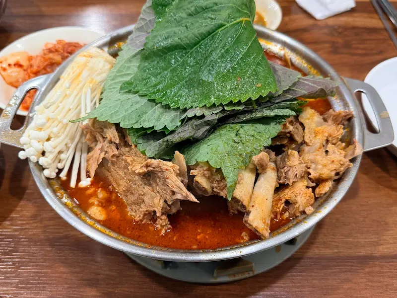 감자탕 위에는 팽이버섯과 깻잎이 듬뿍 올려져 있다.