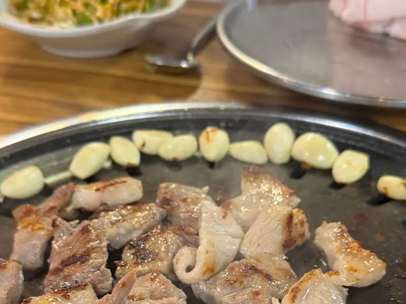 불판 위에서 익어가는 뒷고기와 마늘