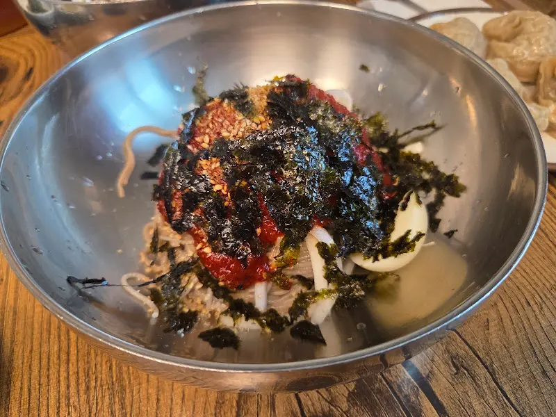 놋그릇에 담겨 나온 회막국수의 클로즈업 샷