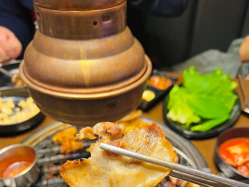 고기와 함께 쌈을 싸서 먹는 모습