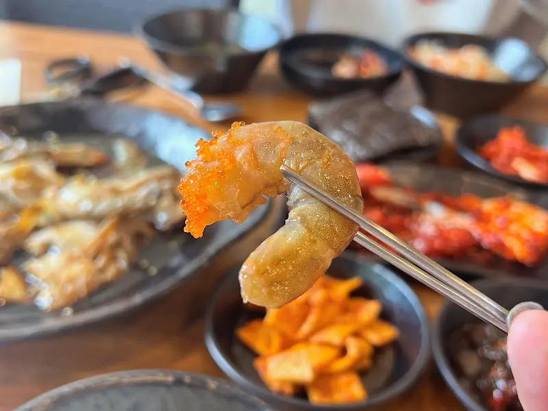 젓가락으로 새우장을 들어 올린 모습