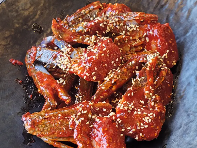 양념게장의 클로즈업 사진. 윤기가 흐르고 깨가 뿌려져 있다.