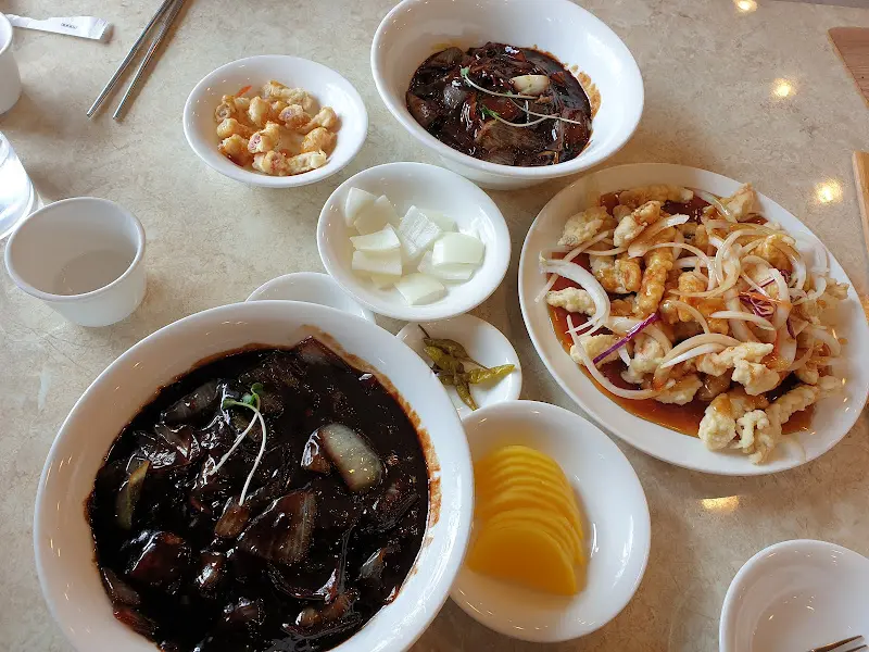 짜장면, 탕수육, 단무지, 양파가 테이블 위에 놓여있는 모습