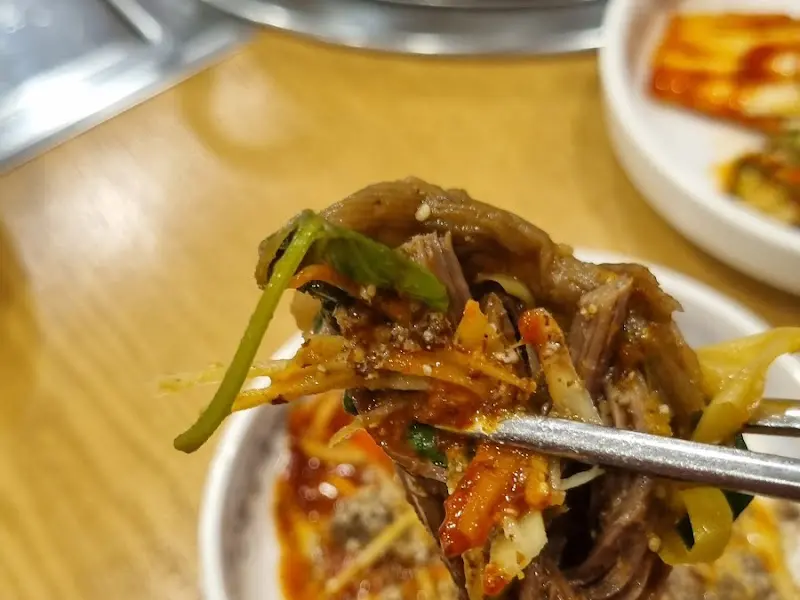 흑염소 고기를 젓가락으로 들어 올린 모습