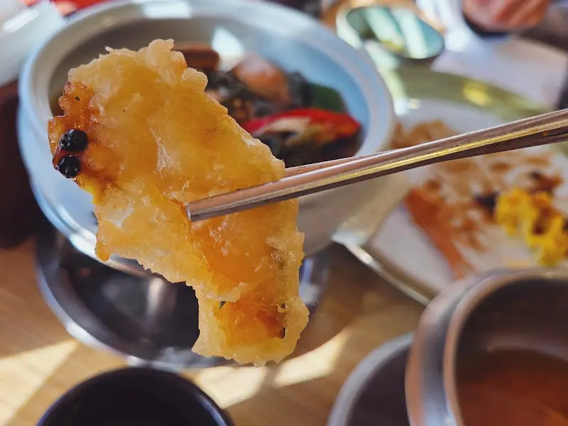 젓가락으로 집어 올린 튀김의 모습