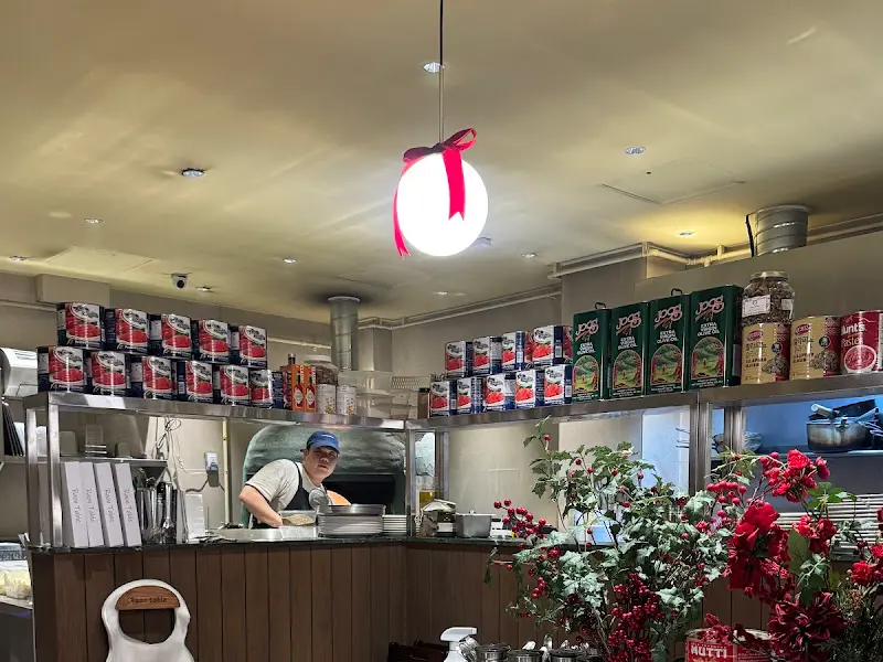 오픈 키친에서 요리사가 피자를 만들고 있는 모습