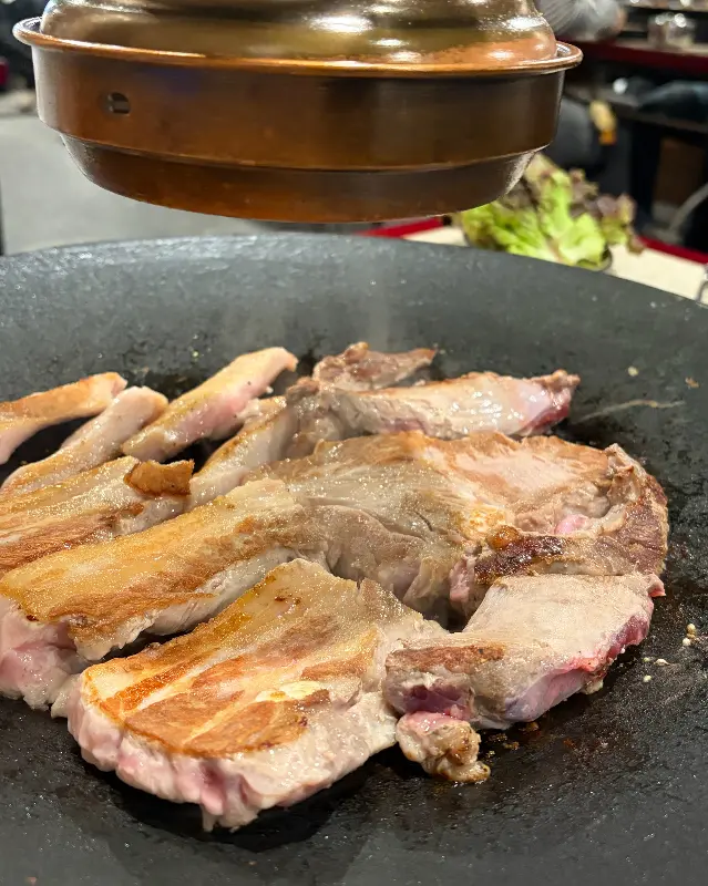 솥뚜껑에 구워지는 돼지고기