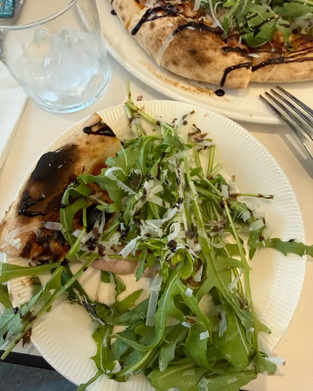 루꼴라가 듬뿍 올라간 피자 한 조각