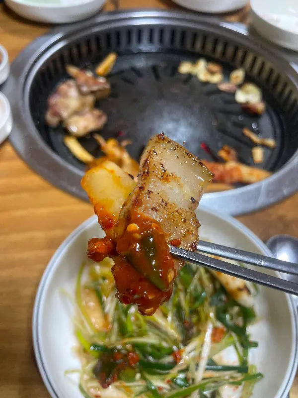 젓가락으로 고기와 양념을 함께 집어 올린 모습