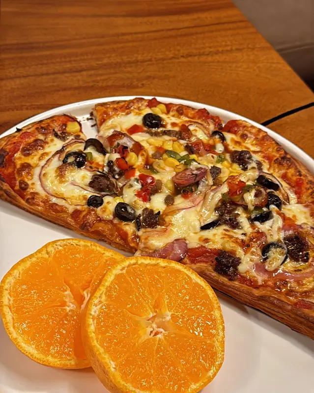 오렌지 슬라이스가 곁들여진 먹음직스러운 피자