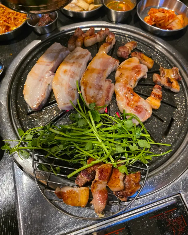 불판 위의 오겹살과 미나리