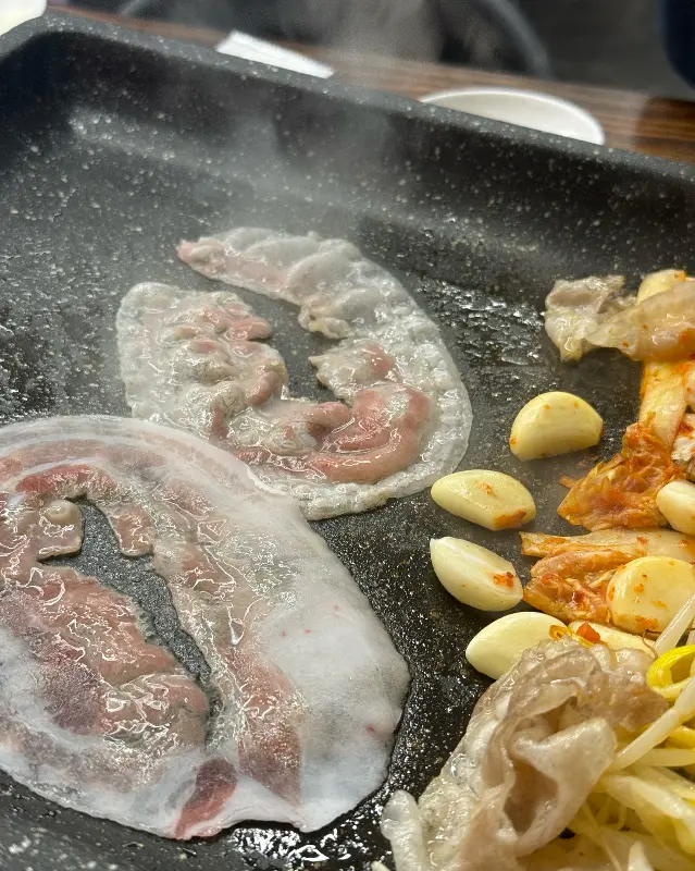 불판 위에서 지글지글 익어가는 냉삼겹살