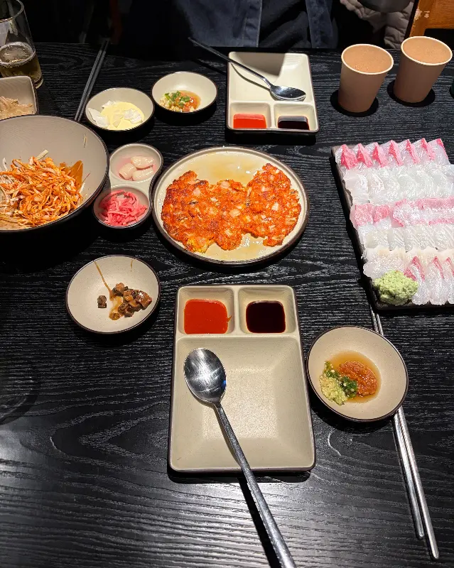 싱싱한 회와 다양한 밑반찬이 가득한 테이블