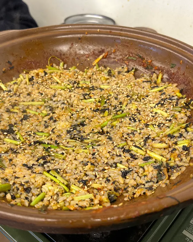 볶음밥이 철판 위에 펼쳐져 있으며, 김가루와 참깨가 뿌려져 있다.