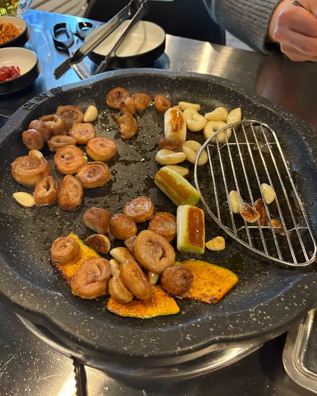 돌판 위에 곱창, 대파, 호박, 마늘이 함께 구워지는 모습