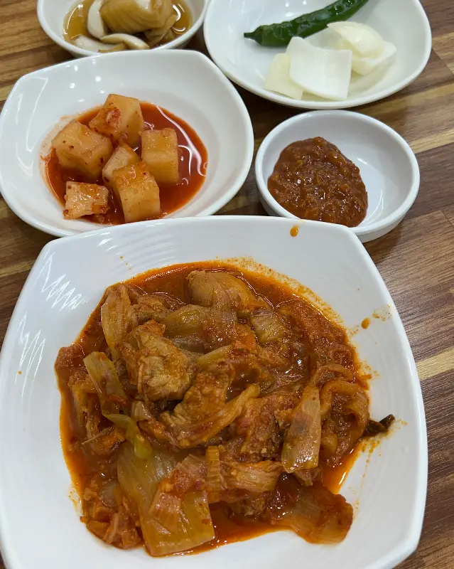 소낭밭의 밑반찬. 흑돼지 김치찜, 깍두기, 김치, 양파 장아찌 등이 정갈하게 담겨 있다.