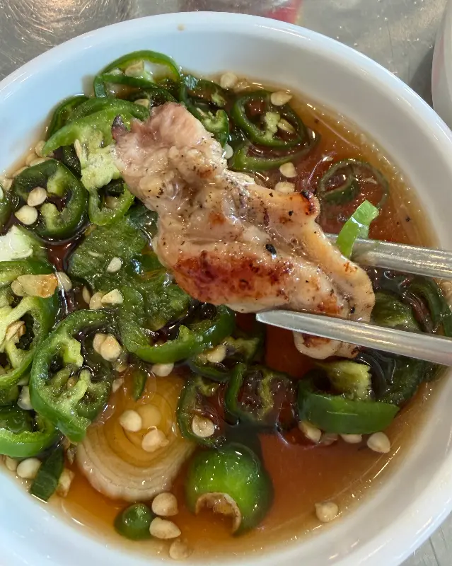 닭목살을 특제 소스에 찍어 먹는 모습