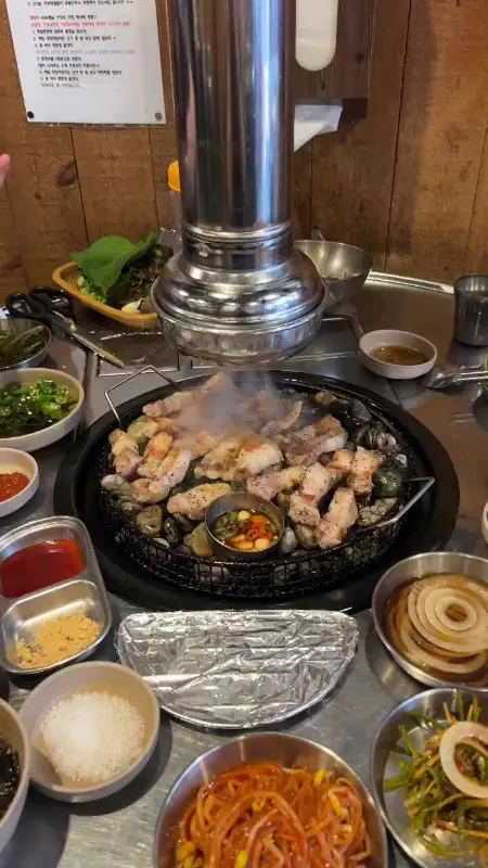 자갈 위에서 연기를 내며 구워지는 고기