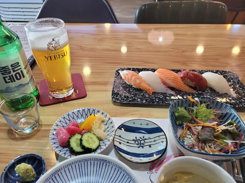 스시, 술, 곁들임이 함께 놓인 테이블