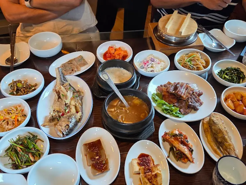 푸짐하게 차려진 한상차림: 돌솥밥, 보리굴비, 황태구이를 중심으로 다양한 반찬들이 놓여있다.