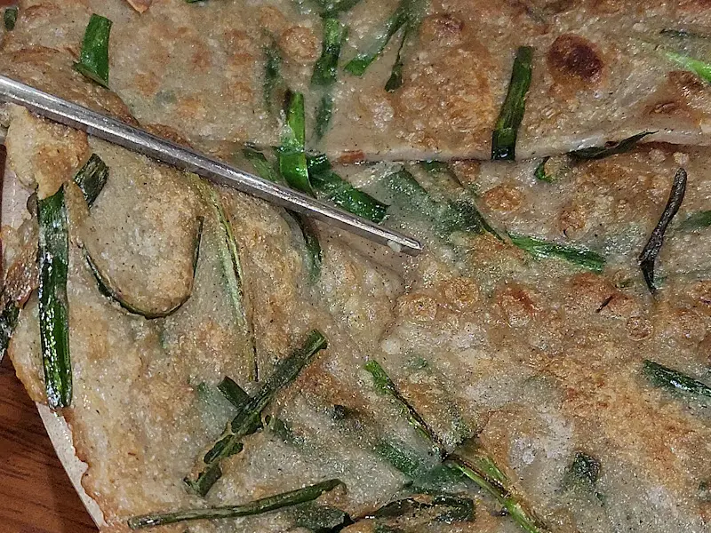 젓가락으로 메밀전을 집는 모습