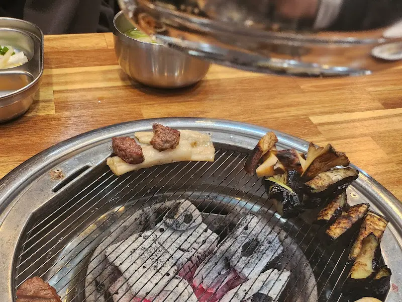 숯불 위에 구워지는 양꼬치와 버섯