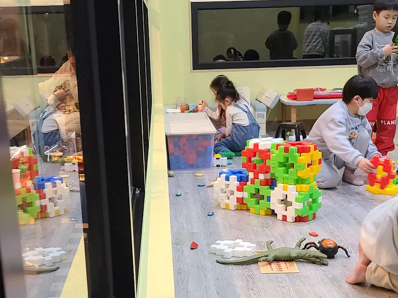 아이들이 실내 놀이방에서 블록 놀이를 하고 있는 모습