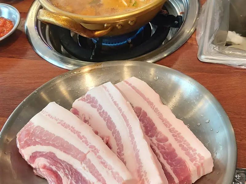 삼겹살과 찌개가 함께 놓인 테이블
