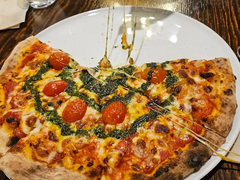 신선한 토마토와 바질 페스토가 올라간 피자