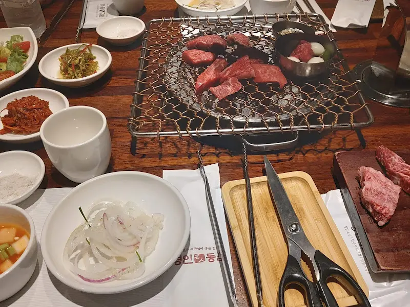 숯불 위에서 익어가는 한우와 다채로운 밑반찬