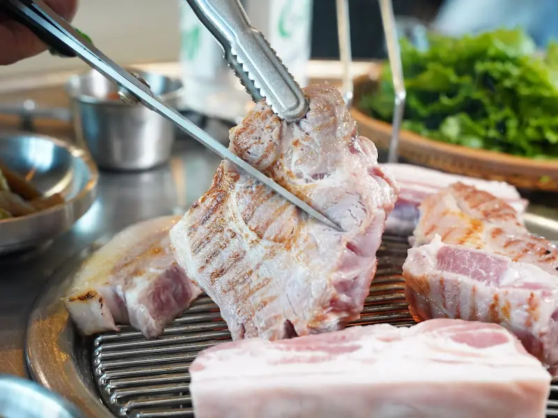 능숙한 솜씨로 흑돼지를 구워주는 직원