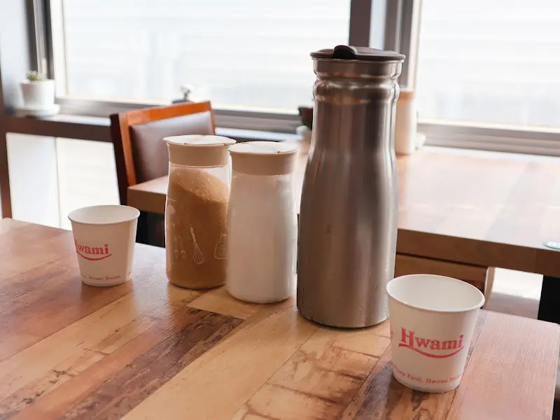 테이블 위에 놓인 물통, 컵, 설탕, 소금