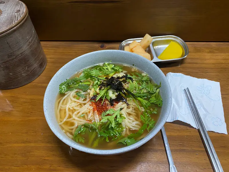 쑥갓과 김가루가 소복하게 올라간 따뜻한 우동 한 그릇