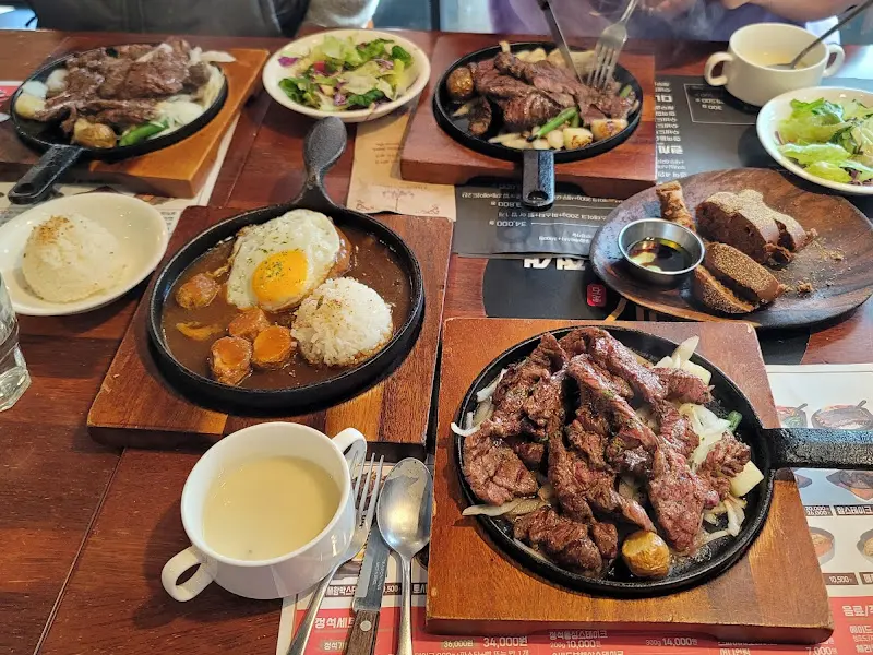 테이블에 놓인 스테이크와 밥, 샐러드