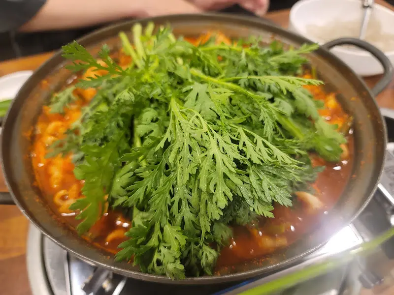 곱창전골 위에 수북하게 쌓인 쑥갓