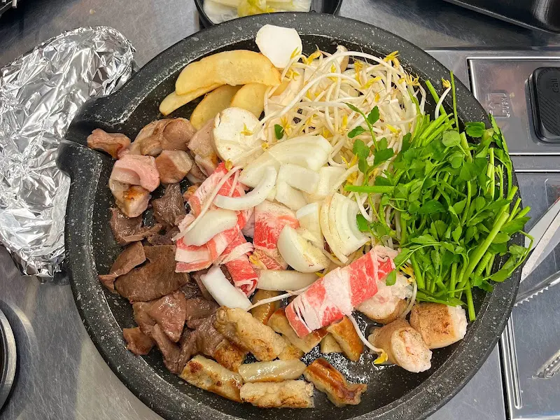 돌판 위에 곱창, 양파, 버섯 등이 함께 구워지는 모습