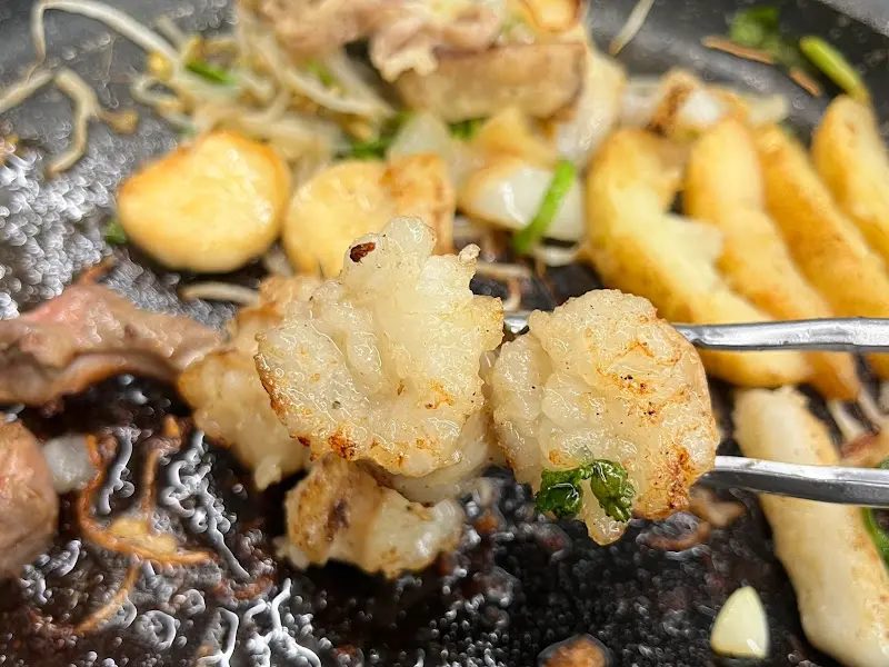 잘 구워진 곱창을 젓가락으로 집는 모습