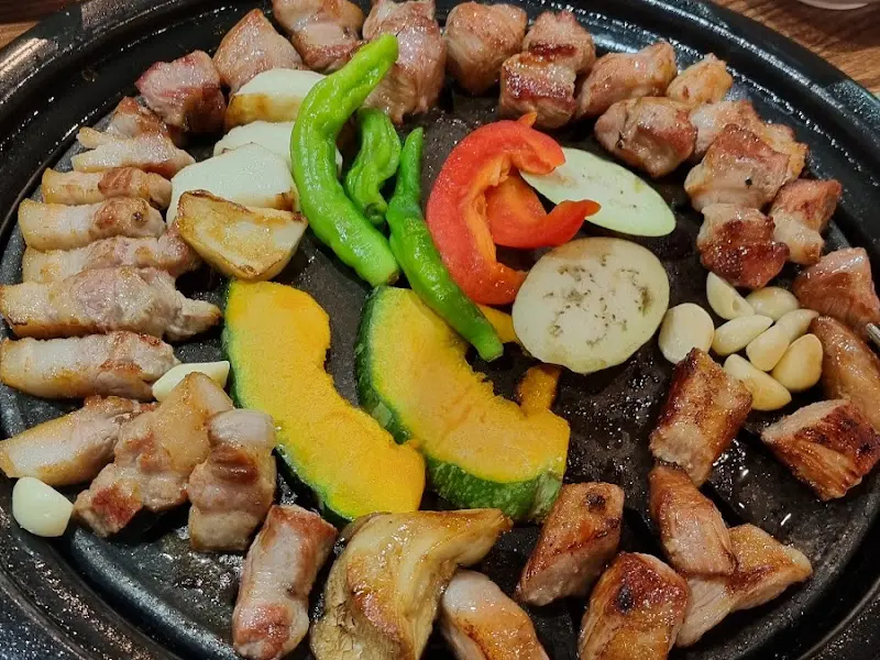 불판 위에 구워진 목살과 야채