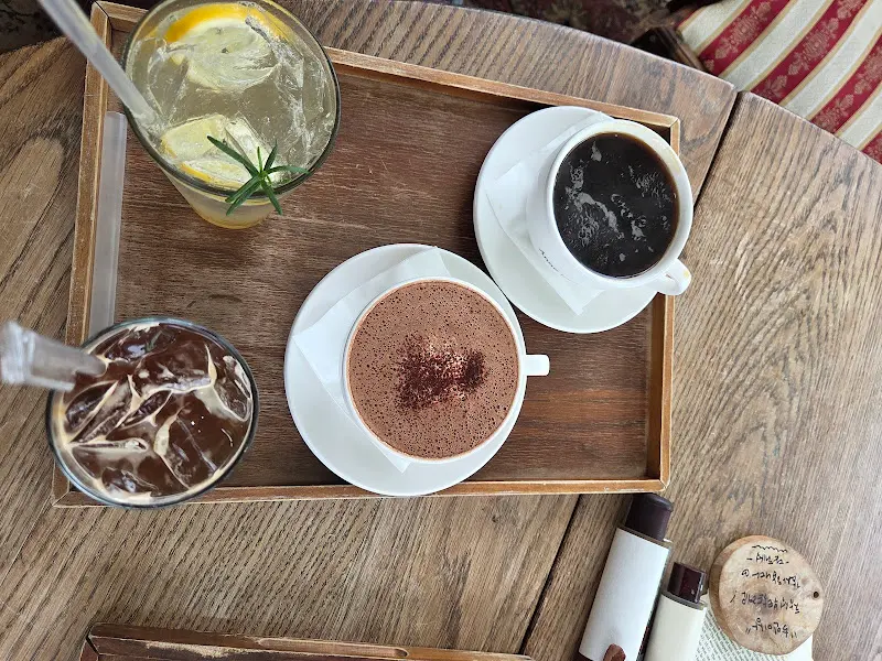 앤트리 카페의 음료 메뉴. 앤 커피, 꿀 아메리카노, 레몬 에이드가 놓여 있다.