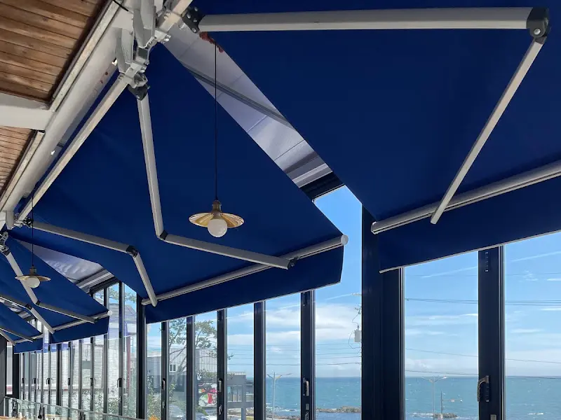 푸른색 어닝이 쳐진 창 밖으로 보이는 바다